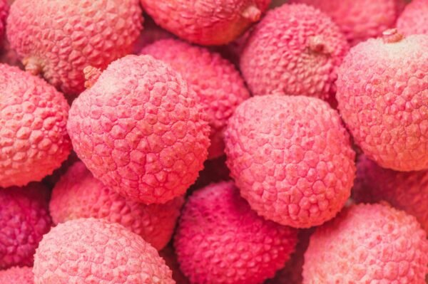 Vibrant close-up of ripe red lychee fruits showcasing their textured skin.