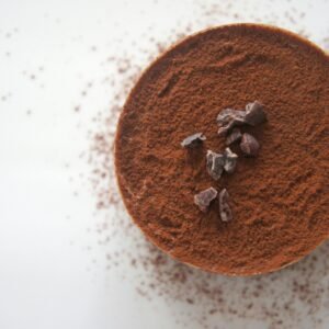 Top view of a rich chocolate dessert dusted with cocoa powder on a white background.